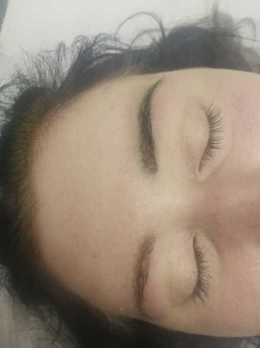 Close-up of a closed eye with a shaped brow and a finished set of lash extensions
