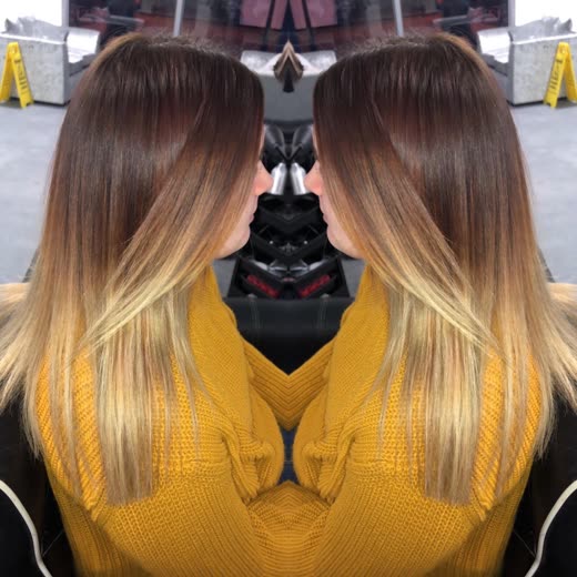 Long brown-to-blonde balayage hair on a client seen from behind in the salon